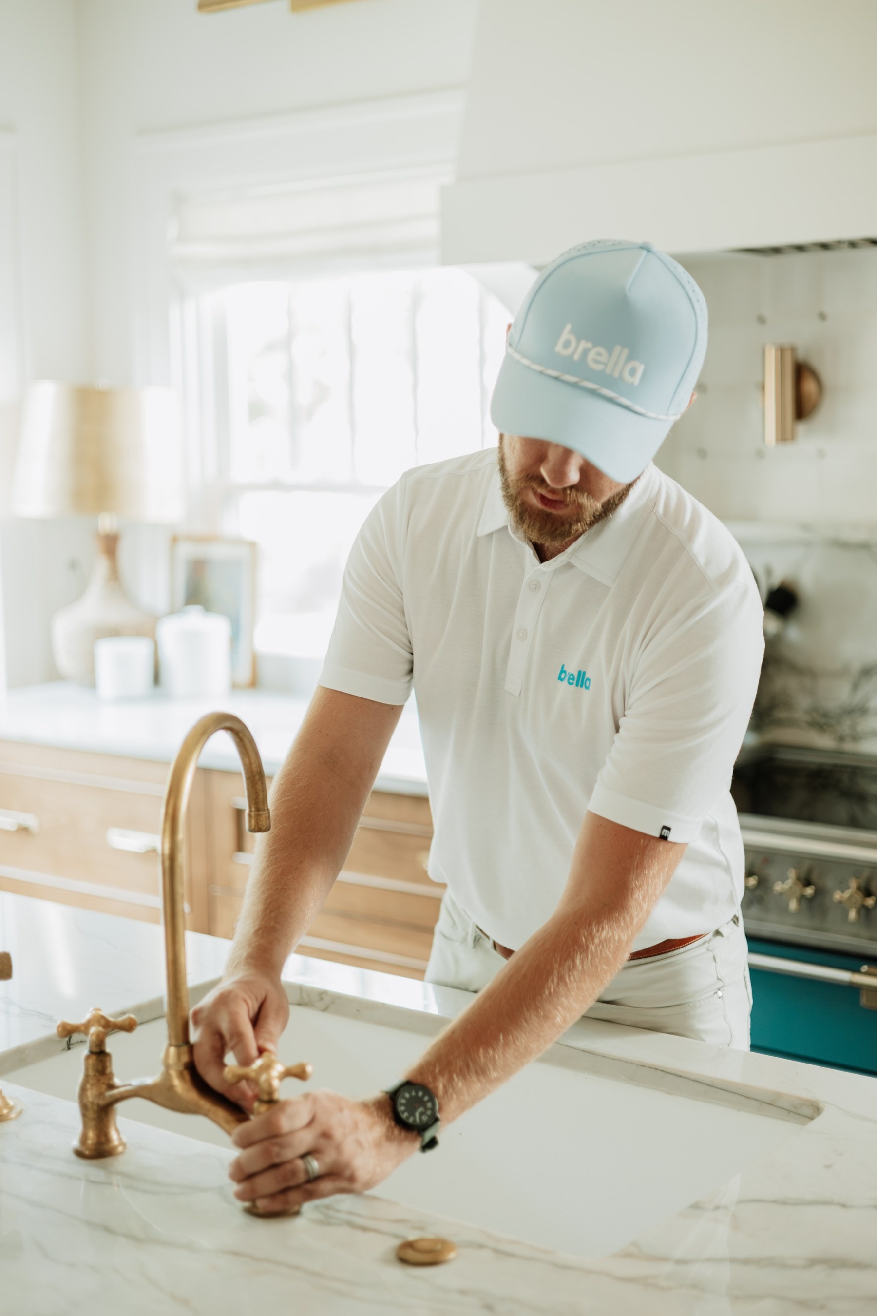 A Brella technician checking a kitchen faucet at the sink
