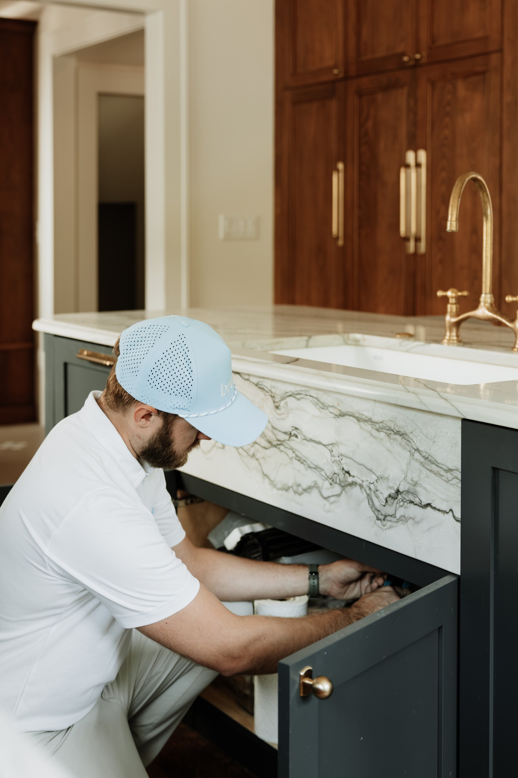 A Brella technician checking the plumbing under a kitchen sink